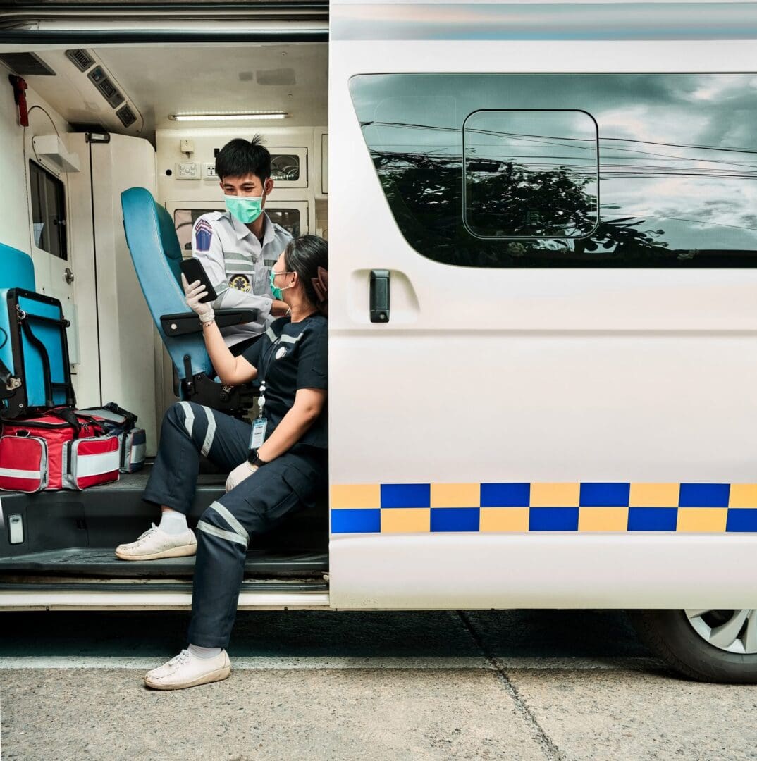 Paramedics sitting inside an open ambulance.