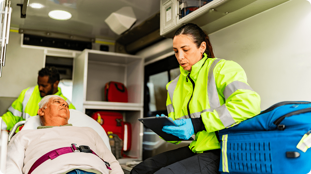 Paramedics assisting patient inside an ambulance.