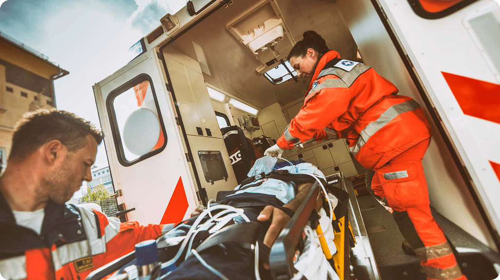 Emergency crew securing stretcher inside ambulance